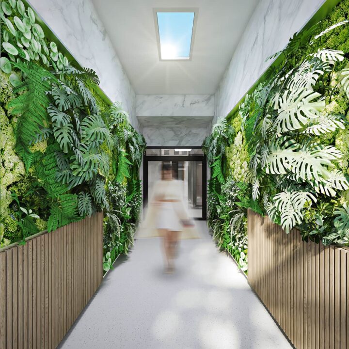 a woman walking in a hallway with plants on the walls