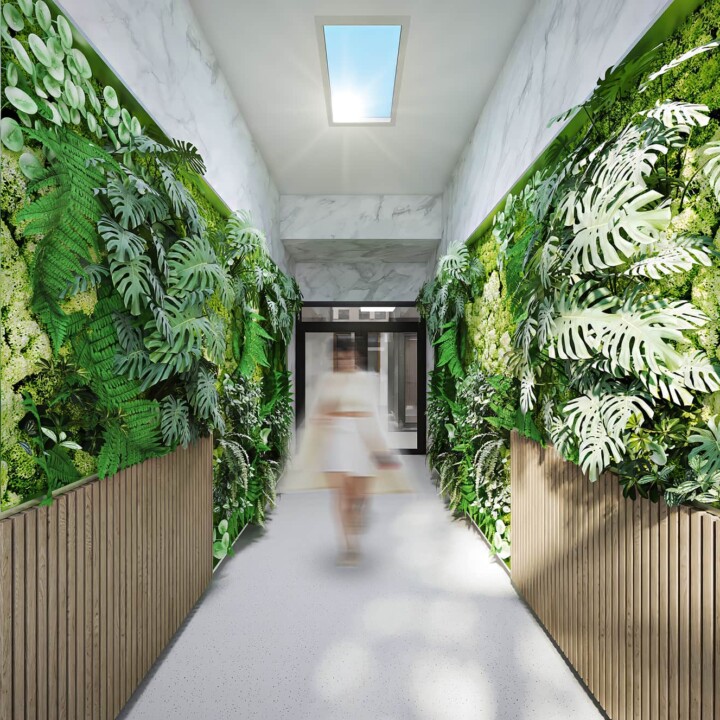 STOCKHOLM - BRF ISLANDET 14-16 3 a woman walking in a hallway with plants on the walls